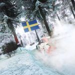 An image of a rally car driving in the snow with a Swedish flag above it in WRC Generations.