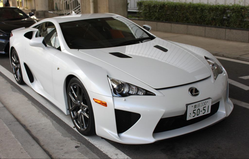 A white Lexus LFA with a Japanese car licence plate parked up.