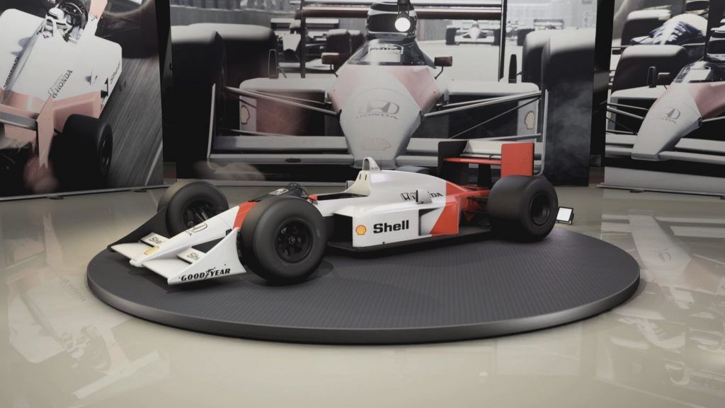 McLaren MP4/4 car in a showroom with images of the car being driven behind.