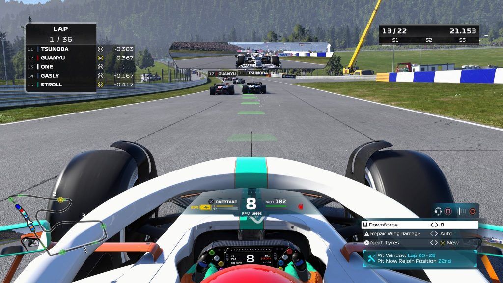 Onboard camera of an F1 car in OverTake colours on the first lap of a race on the Red Bull Ring, with a menu recommending pitting between laps 20 and 28.