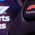 F1 Esports logo in the back of shot with a race seat that has the F1 logo on the headrest.