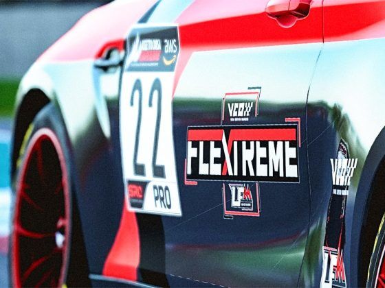 Side closeup of a car with red wheel rims, race number of 22 with the VCO LFM FLExTREME logo on the door.