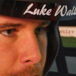 Close up of a man wearing an open face helmet saying 'Luke Wallace' at the top.