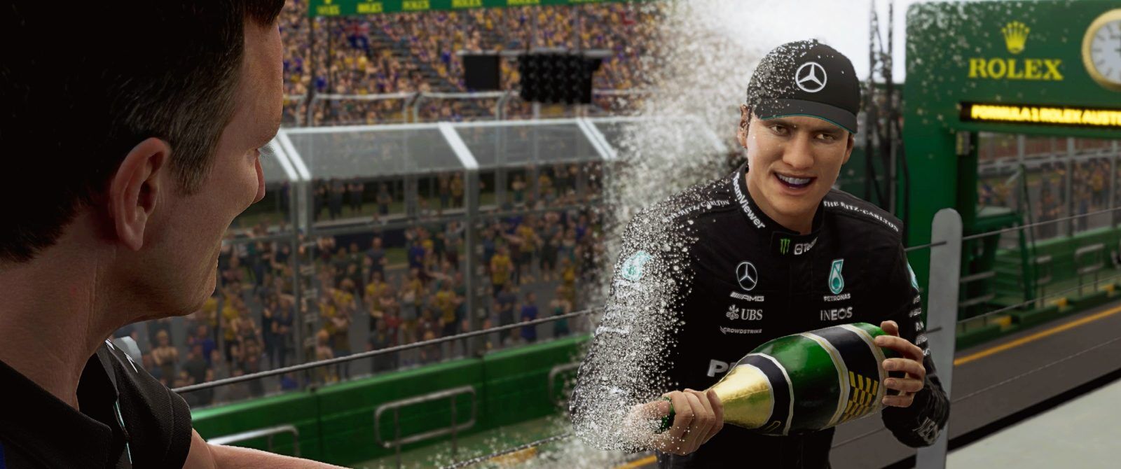 A guy in Mercedes overalls spraying champagne overlooking a racetrack.