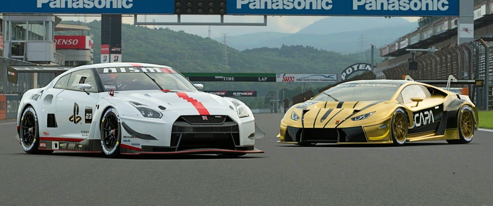 A white Nissan GT-R racecar (left) and a gold Lamborghini Huracán racecar (right) parked on a racetrack's start/finish straight.