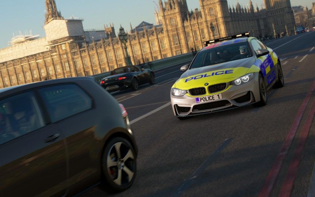 A BMW M4 in a British police livery chasing a VW hatchback on Westminster Bridge in London.