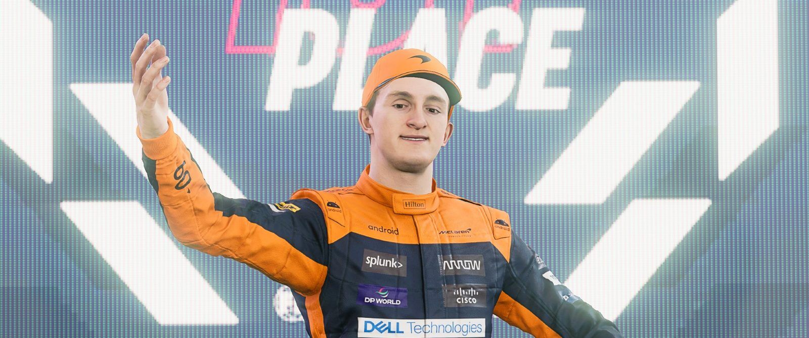 A person in an orange set of overalls and cap holding a trophy.
