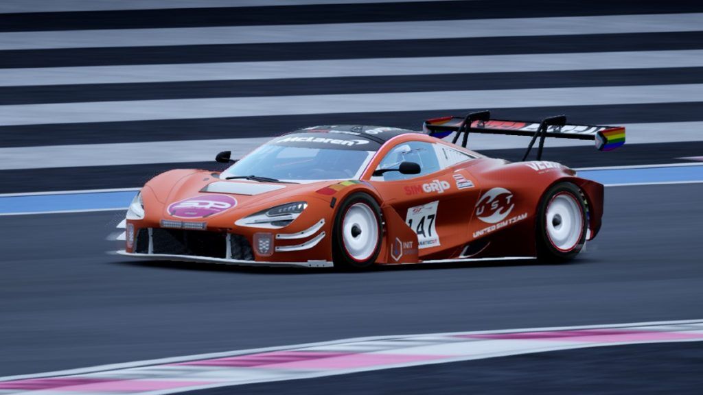 An orange and dark red McLaren racing car with a big pink circle on the front with 'SOP' in the middle.