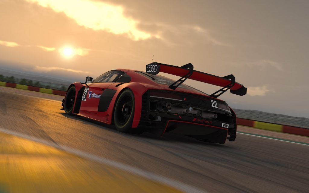 A red and black racecar driving at near sunset.