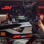 A sim racing setup with two people sat in rigs, one behind the other.