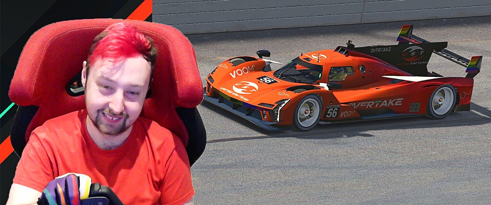 On the left is a man with bright red hair in a red shirt, with a prototype racing car on the right.