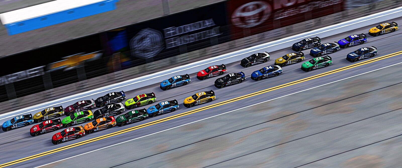 A line of NASCAR stock cars racing.