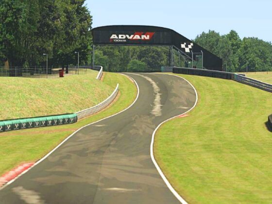 A trackside shot of a racetrack with a piece of track heading over a crest in the distance.