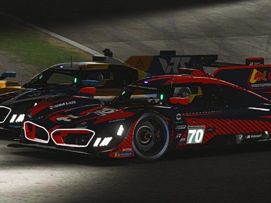 Two low slung bespoke racing cars side by side at nighttime on a racing track.