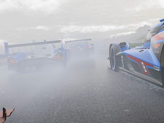 Racing cars driving in rainy conditions with spray being kicked up.